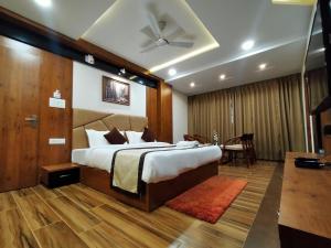 a bedroom with a large bed and a table at Hotel Royal City in Siliguri