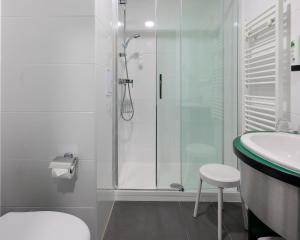 a bathroom with a shower, toilet and sink at Hotel Malá Strana in Prague