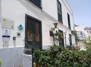 a white building with a black door and some plants at Studio Askanova in Valle Gran Rey