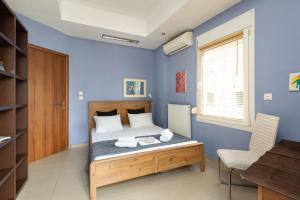 Delmare Dahlia double apartment في سلانيك: غرفة نوم بجدران زرقاء وسرير ومكتب