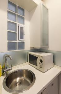 a kitchen with a sink and a microwave at Delmare Dahlia double apartment in Thessaloniki