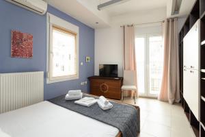 a blue bedroom with a bed and a television at Delmare Dahlia double apartment in Thessaloniki