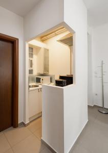 una cucina con armadi bianchi e bancone in camera di Delmare Dahlia double apartment a Salonicco