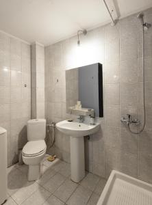 a bathroom with a toilet and a sink at Delmare Dahlia double apartment in Thessaloniki