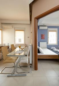 テッサロニキにあるDelmare Dahlia double apartmentのベッド、ガラスのテーブルと椅子が備わる客室です。