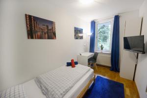 Schlafzimmer mit einem Bett, einem TV und einem Fenster in der Unterkunft Basement Rotherbaum in Hamburg