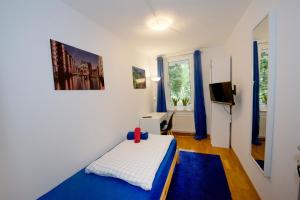 a small room with a bed and a tv at Basement Rotherbaum in Hamburg