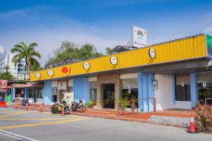 a yellow building with motorcycles parked in front of it at JMA FERRINGHI BEACH HOTEL in Batu Ferringhi