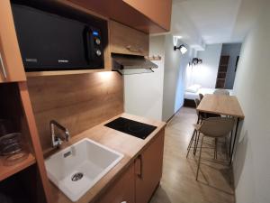 a small kitchen with a sink and a microwave at Apparthotel Torcy in Torcy