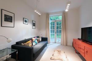 a living room with a couch and a tv at Apartment 2 The Grove in Durham