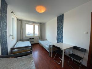 Habitación con mesa, cama y escritorio. en Pokoje PANORAMA CITY VIEW- Centrum, en Varsovia