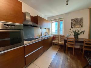 Una cocina con gabinetes de madera y un comedor. en Pokoje PANORAMA CITY VIEW- Centrum, en Varsovia