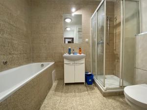 Un baño con bañera, lavabo y ducha. en Pokoje PANORAMA CITY VIEW- Centrum, en Varsovia 21 fotos más