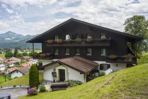 ein Haus auf einem Hügel mit Blumen in der Unterkunft Ferienwohnung Stigloher im Bergschlößl in Oberaudorf