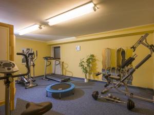 a gym with several exercise equipment in a room at Ferienwohnung Stigloher im Bergschlößl in Oberaudorf