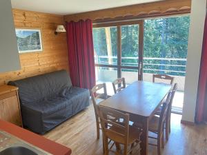 a living room with a table and a couch at apt 4/6 pers aux villages du Bachat chamrousse in Chamrousse