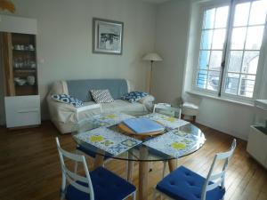 a living room with a table and chairs and a couch at Appartement Hypercentre Quimper in Quimper