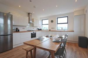 a kitchen with a wooden table and a refrigerator at Contemporary 2 Bedroom Apartment with Parking in Bristol
