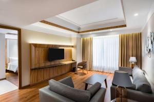 a living room with a couch and a television at Radisson Bhopal in Bhopal