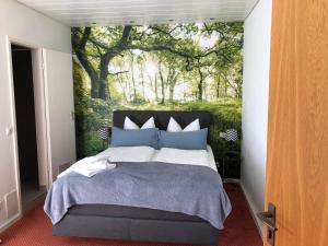 a bedroom with a large tree mural on the wall at Haus am Wald in Eltmann