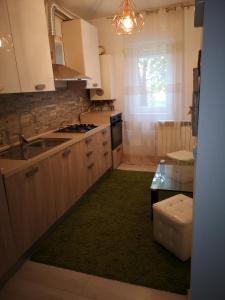 cocina con armarios blancos y alfombra verde en Apartament Darius, en Târgu Ocna