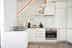 a kitchen with white cabinets and a staircase at Charming house with terrace in Lisbon.WIFI. in Lisbon