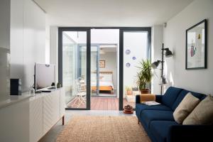 a living room with a blue couch and a bedroom at Charming house with terrace in Lisbon.WIFI. in Lisbon