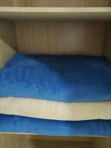 a bed with blue sheets on a wooden shelf at Apartamento na Av Atlantica com Ar Condicionado in Balneário Camboriú