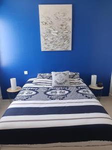 Un dormitorio azul con una cama con una pared azul. en APPARTEMENT FACE au PORT et à L'OCEAN SAINT GILLES CROIX DE VIE WIFI BALCON PARKING PRIVE COUVERT, en Saint Gilles Croix de vie