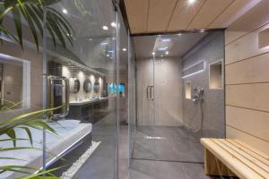 a bathroom with a shower and two sinks at Iakovakis Suites & Spa in Koropi