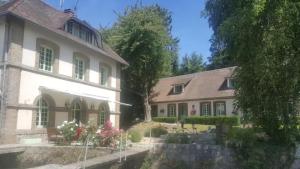 una grande casa bianca accanto a un edificio di CHAMBRE D'HOTE AU MOULIN DE LONGUEIL a Longueil