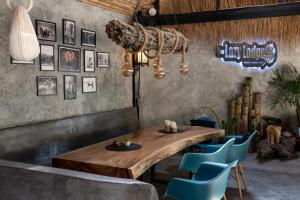 a dining room with a wooden table and blue chairs at The Lazy Lodge in Ko Lanta