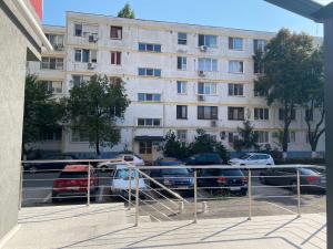 un parking avec des voitures garées devant un bâtiment dans l'établissement Apartament - Drumul Taberei Parc Residence, à Bucarest