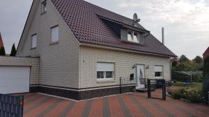 a house with a gambrel roof on a brick driveway at Nettes 2- Zimmer Apartment in Sehnde