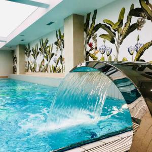 a swimming pool with a waterfall in a hotel room at Afrodyta Spa in Świnoujście