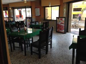 a dining room with green tables and chairs at Hotel El Diamante CA in Barranquilla