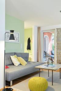 uma sala de estar com um sofá e uma mesa em Rotes Haus Bregenz Garten Wohnung em Bregenz