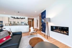 sala de estar con sofá y chimenea en Alpen panorama luxury apartment with exclusive access to 5 star hotel facilities en Davos