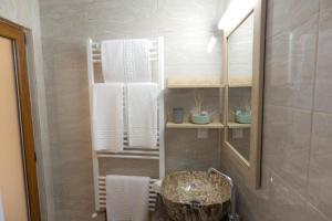 a bathroom with a sink and towels and a mirror at La Helesteu in Lăzăreşti