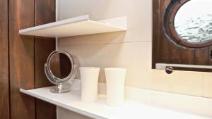 a shelf with two stacks of paper cups and a mirror at Ferienhaus Drebach in Drebach +49 photos