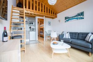 uma sala de estar e cozinha com um sofá e uma mesa em Stunning renovated studio with mezzanine em Morzine