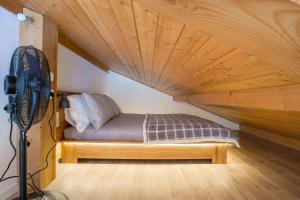 a bed in a room with a wooden ceiling at Stunning renovated studio with mezzanine in Morzine