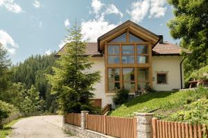 una casa en una colina con una valla en Ciasa Iachin Mountain Apartment en San Martino in Badia