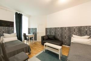 a room with two beds and a couch and a chair at Sleep Like Home Winsviertel in Berlin