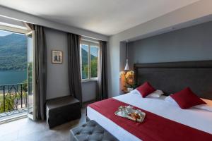 a bedroom with a large bed and a large window at Hotel Ristorante La Quartina in Mergozzo