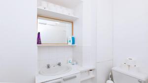 a white bathroom with a sink and a mirror at Studio Flat at Paddington Central London Zone 1 in London