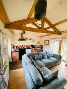 a living room with a blue couch and a kitchen at Field Farm Holiday Cottages and Glamping in Anderby