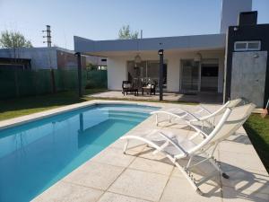 a pair of chairs sitting next to a swimming pool at DOLCE LUNA in Roldán
