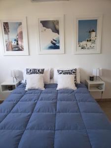 a large blue bed in a room with pictures on the wall at DOLCE LUNA in Roldán