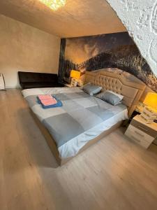 芬洛的住宿－MG BB，卧室内的一张大床,墙上有绘画作品